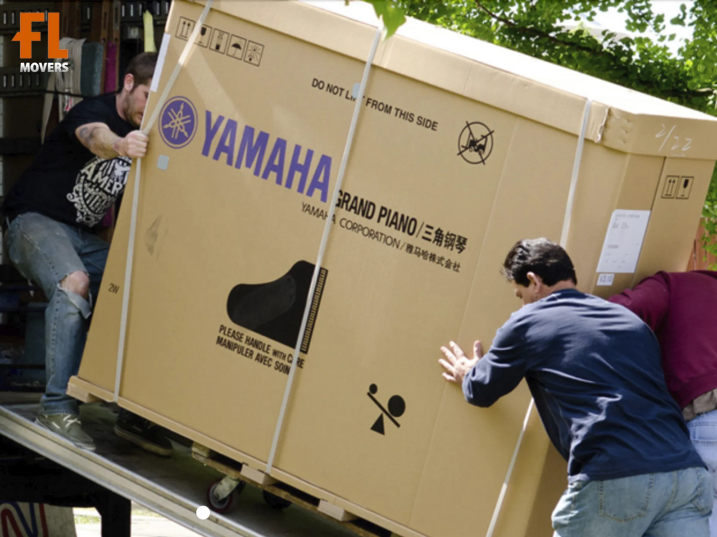 Piano Moving Team Members Loading Instrument in Truck